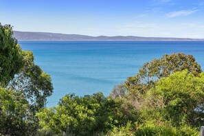A coastal landscape with a view of the sea and distant hills.