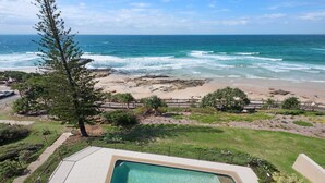 Une piscine avec vue sur l’océan et la plage.