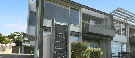 A modern two-story building with large windows and a balcony.