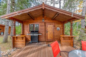 Una cabana de fusta amb terrassa coberta, una barbacoa i un rètol que indica que és el número 20.