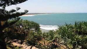 A coastal landscape with a beach, ocean, and dense vegetation. - Shipton Lodge unit 3 Moffat Beach QLD (MOFFAT BEACH)