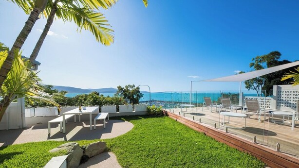 A rooftop terrace with outdoor seating, a view of the ocean, and a clear sky. - A Point of View - Airlie Beach (Airlie Beach)