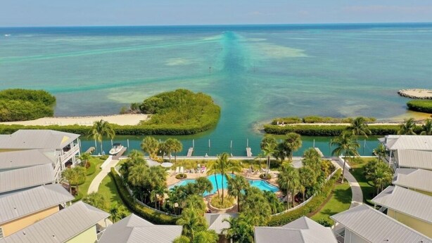Ein Resort mit Pool, Palmen und Meerblick.