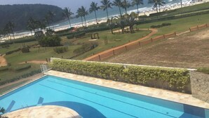 Ein Pool mit Blick auf den Strand und Palmen.