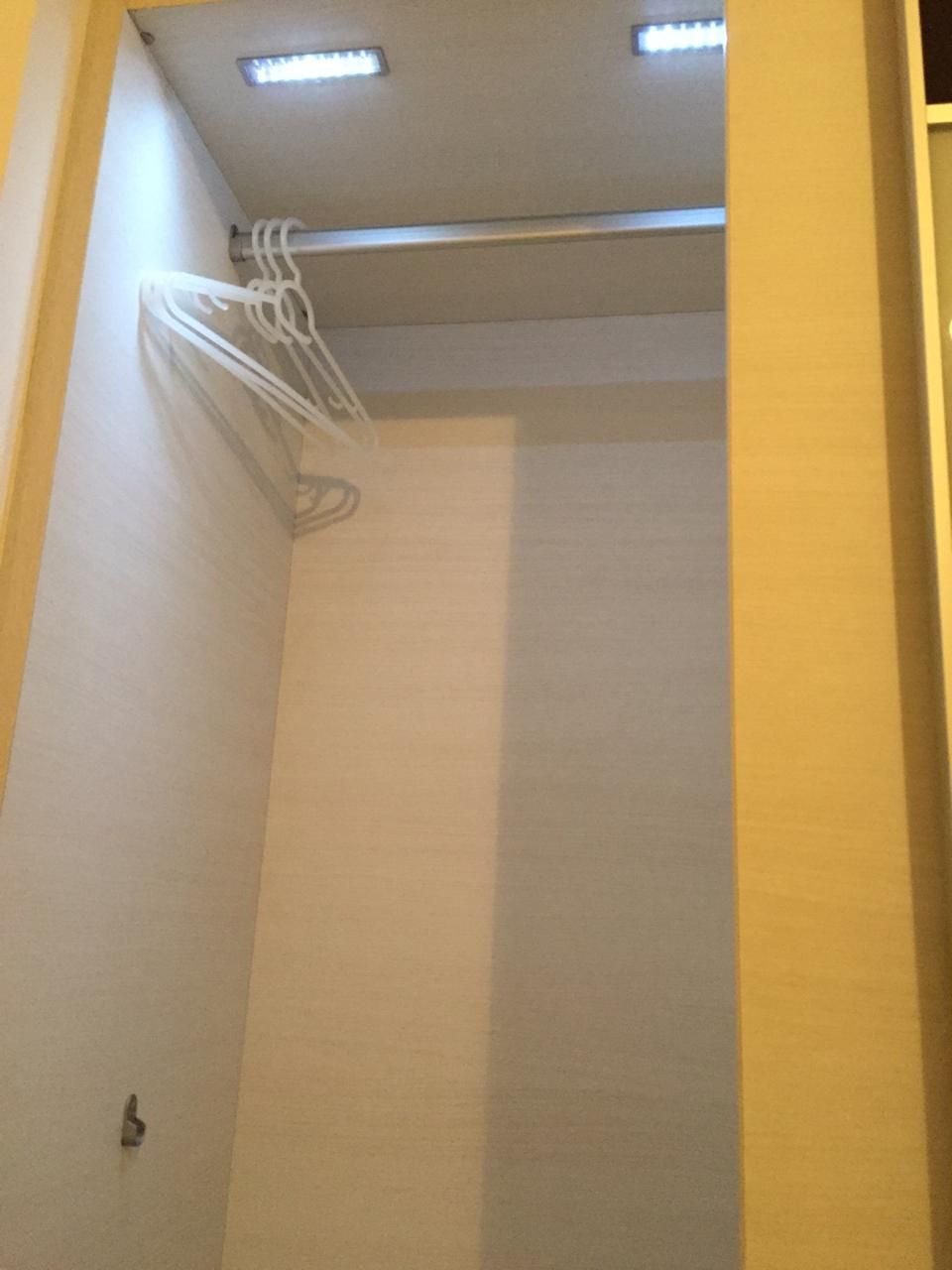 Una esquina de una habitación con una lámpara en el techo y un picaporte.
