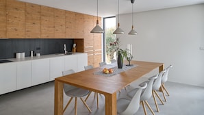 A modern kitchen with white cabinets, a wooden countertop, and pendant lighting. - Luxury Modern Seaview Villa  With  Private Pool In Klimno ***** (Klimno)