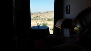 A room with a view of a dry, hilly landscape through an open door. - LA ALMORZARA BALCONY (Priego de Córdoba)