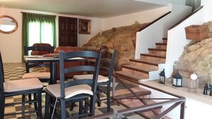 A dining area with a checkered floor, a table, and chairs. There is a staircase with a stone wall and a lantern. - LA ALMORZARA BALCONY (Priego de Córdoba)