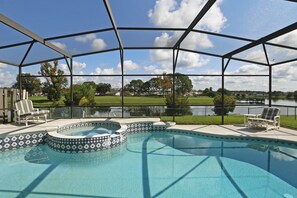 A swimming pool with a covered area, surrounded by chairs, and a view of a lake and park. - Waterview ,Private Pool, Family Friendly, Spacious and Relaxing (Kissimmee)