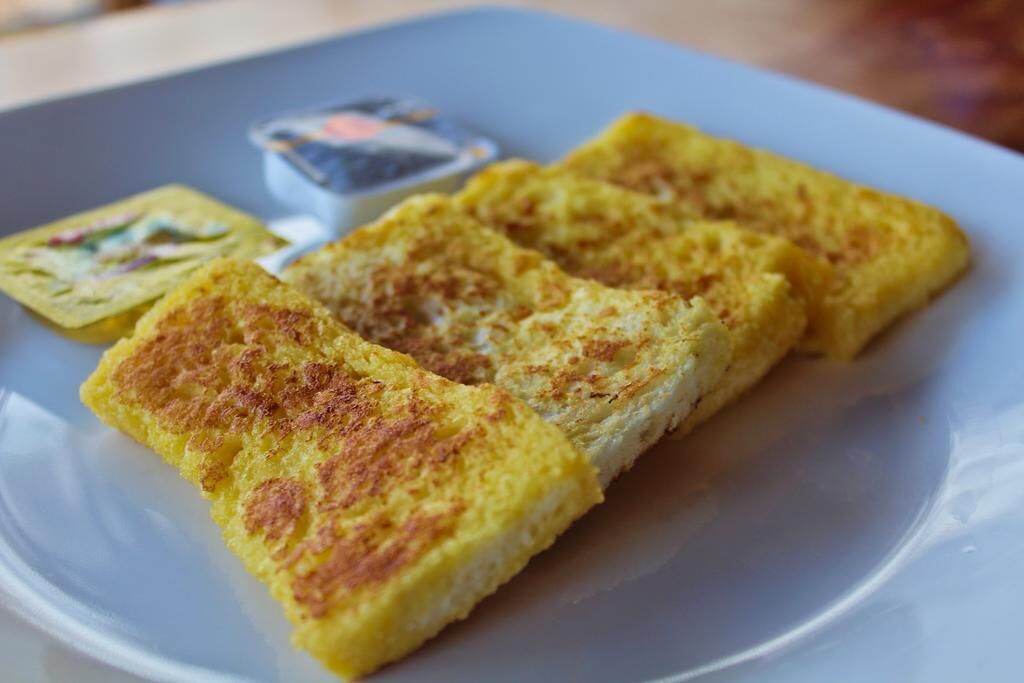 A plate with three pieces of food, possibly a type of omelette or pancake, on a white plate.