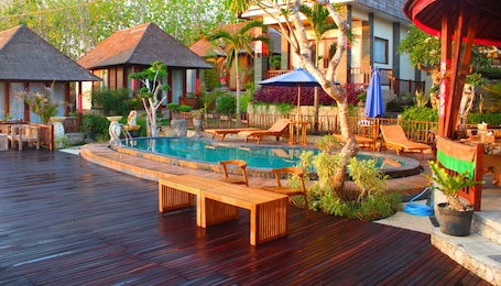 Una piscina al aire libre, sillones reclinables de piscina
