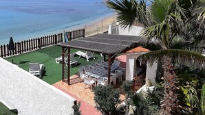 Een terras aan het strand met zitplaatsen buiten en uitzicht op de oceaan.