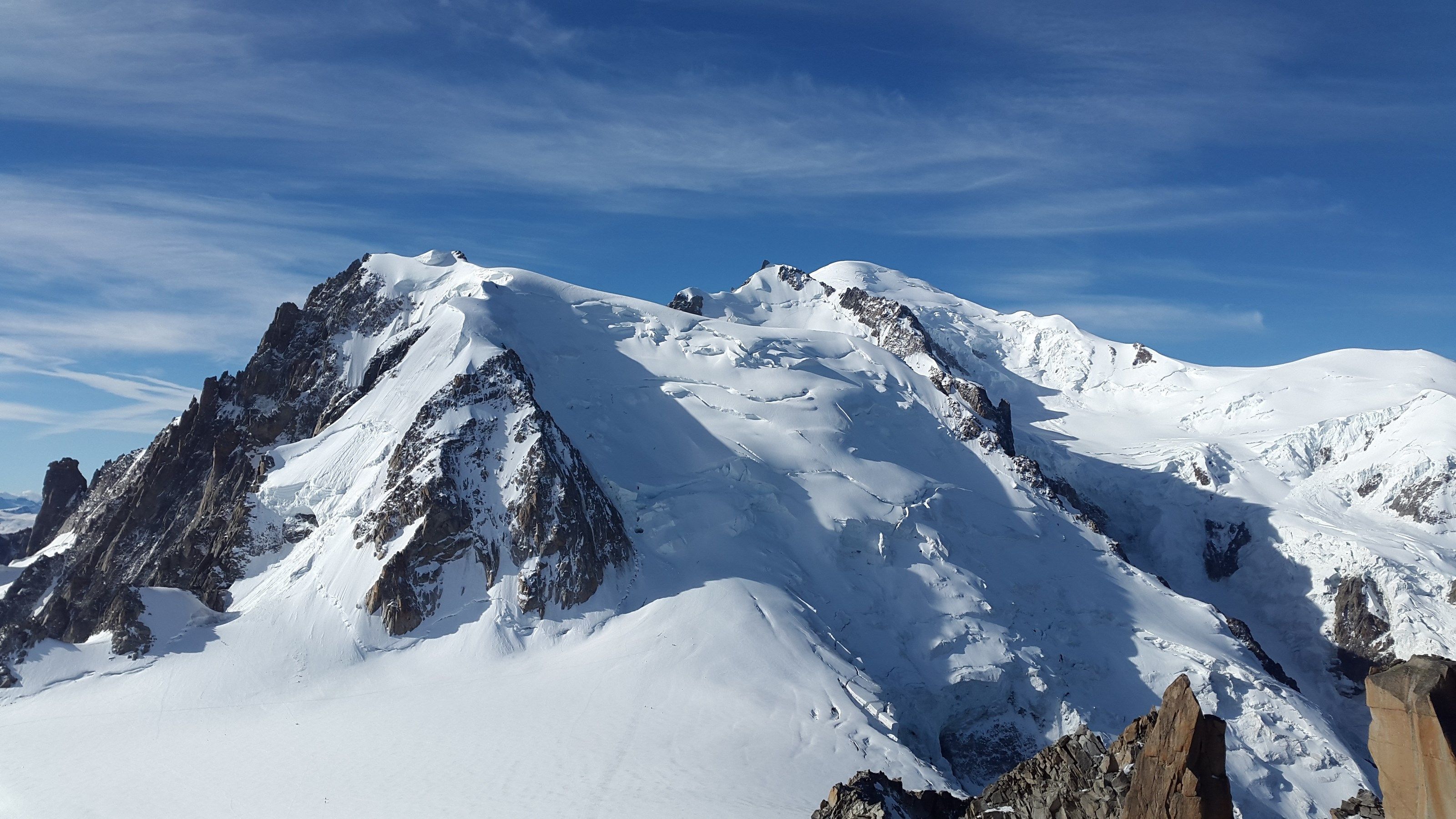 Une montagne enneigée, aux pics acérés et aux affleurements rocheux.