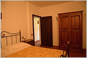 Cozy retreat with a comfortable bed, a wardrobe for storage, and a simple design.
