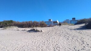 A sandy beach with buildings in the background. - Near Delmar (house 2) (Mar Azul)