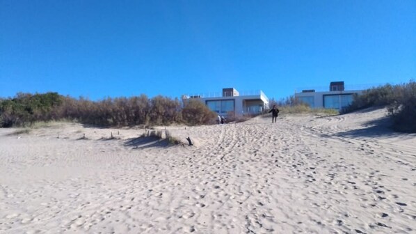 A sandy beach with buildings in the background.