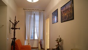 A room with a bed, a chandelier, a window with curtains, and a framed picture on the wall. - apartment In the heart of Rome wonderful view front of the Colosseum discounts (Roma)