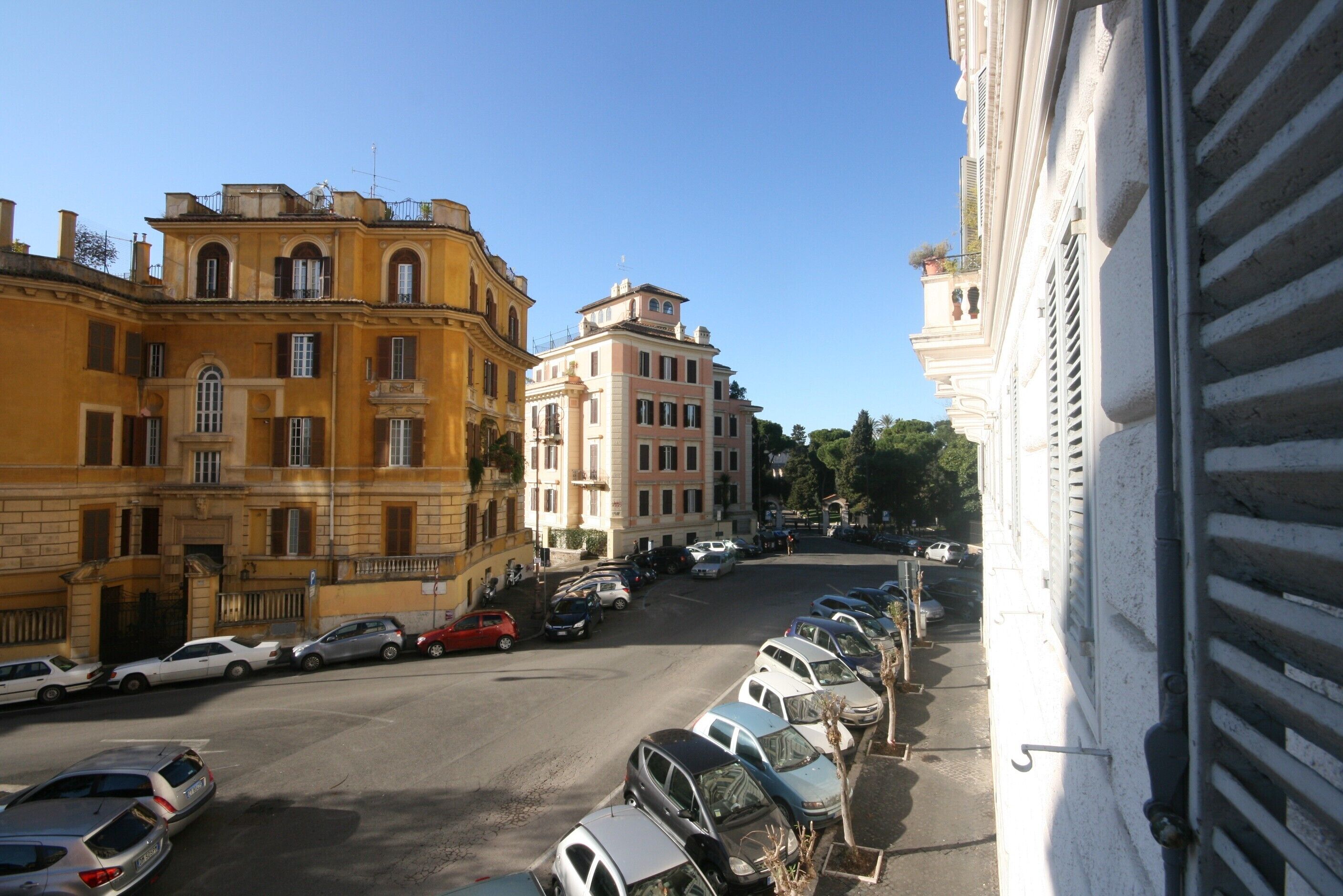 A street view with parked cars and buildings.