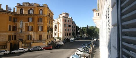 A street view with parked cars and buildings.