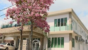 A modern building with a covered entrance, a large metal sculpture, and a parked car. - Tropical Villa Kuantan (Kuantan)