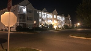 A multi-story residential building with balconies, a stop sign, and street lighting. - Beautiful Rehoboth Beach Condo! 3 bed 2 bath! 2 Pools! Tennis! Gym!  (Rehoboth Beach)