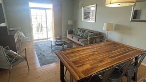 A spacious living area with a wooden dining table, modern chairs, a sofa, and a ceiling fan. - Beautiful Rehoboth Beach Condo! 3 bed 2 bath! 2 Pools! Tennis! Gym!  (Rehoboth Beach)