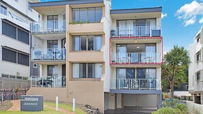 Un immeuble résidentiel à plusieurs étages, doté de balcons, d’une entrée sécurisée et d’une enseigne indiquant le nom « JAMARKOS ».