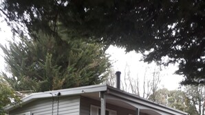 A single-story mobile home with a front porch, a small set of stairs, and a covered outdoor area.