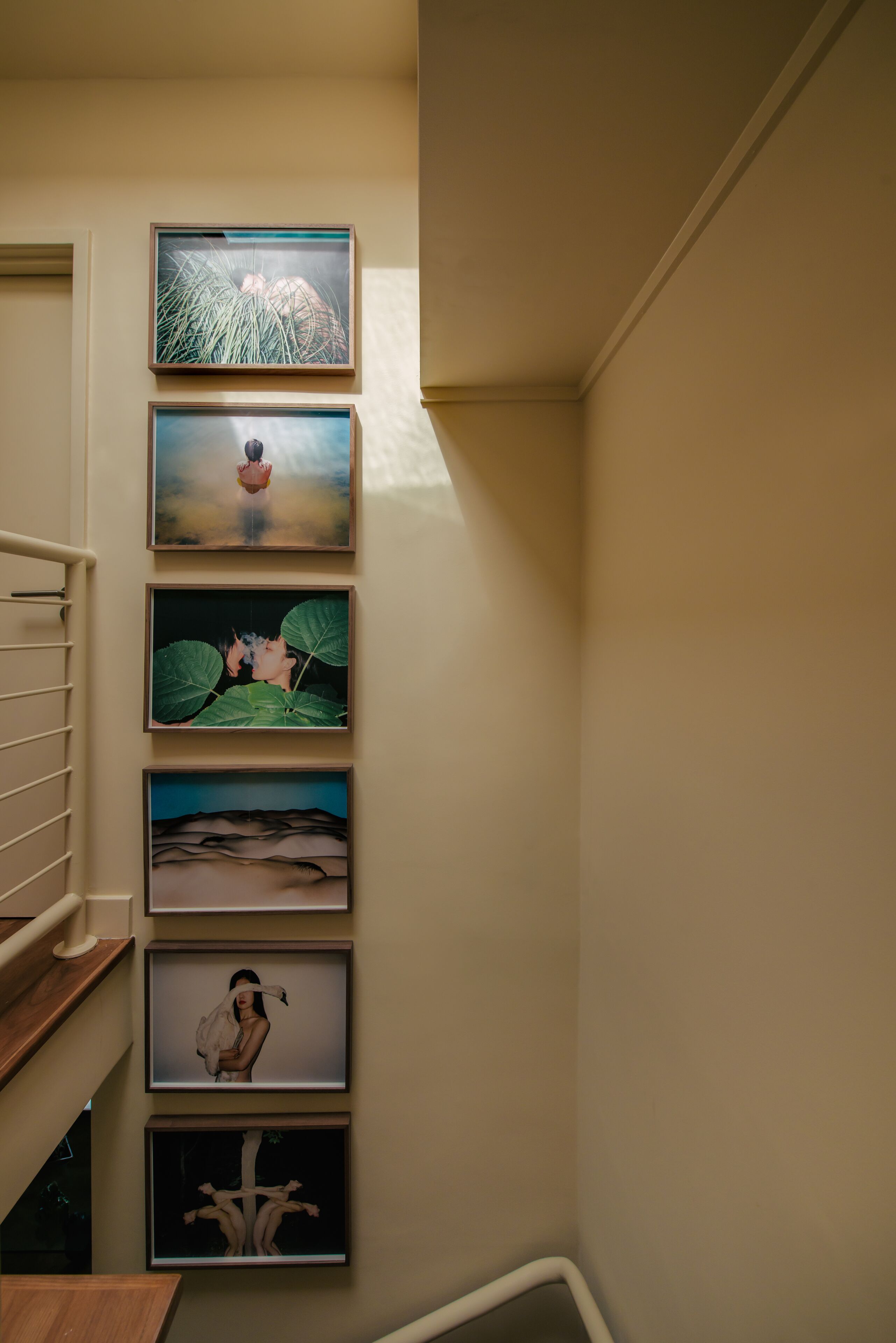 Een trap met kunstwerken in lijsten aan de muur.