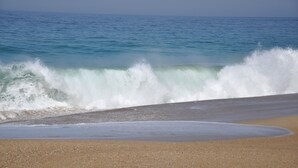 Ein Strand mit brechenden Wellen.