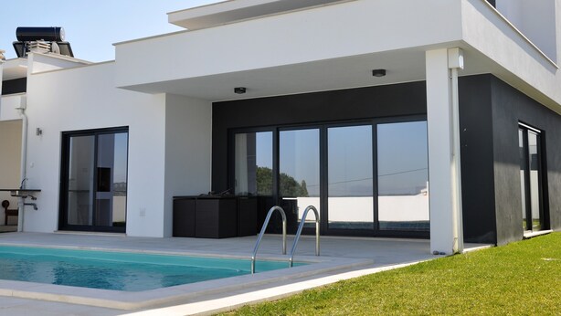 Ein modernes Haus mit Schwimmbad, großen Schiebegläsern und minimalistischem Design.