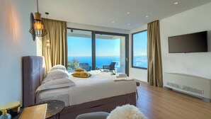 Une chambre d’hôtel moderne dotée d’un grand lit, d’une télévision à écran plat et offrant une vue sur la ville.
