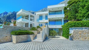 Une villa moderne avec une façade en pierre, de nombreux balcons et une enseigne indiquant « Villa Bellevue ».