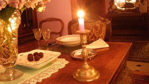 Mesa de jantar com vela, pratos e um vaso de flores.
