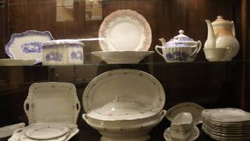 A display of white and blue patterned china, including plates, bowls, and teapots, arranged on shelves.