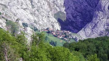 A village nestled in a valley with a steep cliff face.