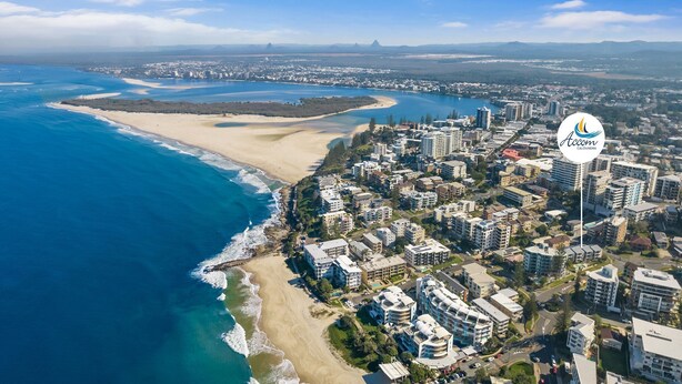 Oversigtsbillede af en kystby med et hotel ved strandkanten, Accom Caloundra.
