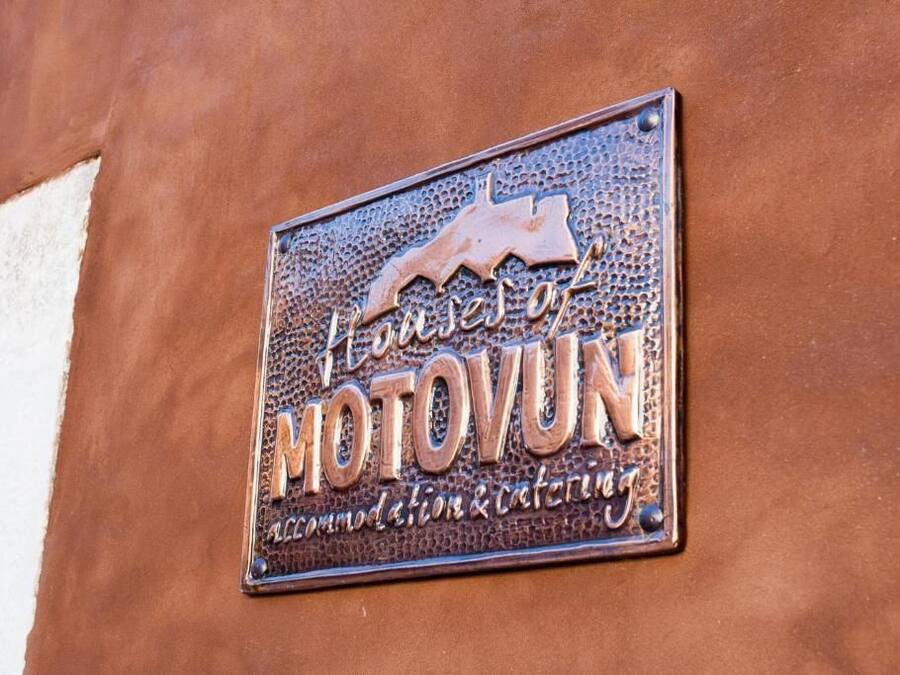 Letrero en una pared marrón con el texto 'House of MOTOVUN' y 'Alojamiento y catering'.