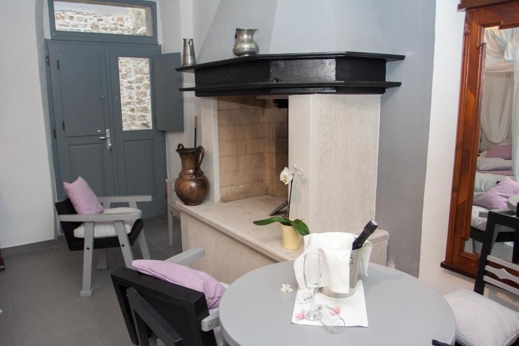 A cozy room with a fireplace, a dining table with a vase of flowers, and a chair.