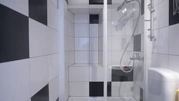 Un baño moderno con ducha de vidrio, inodoro y lavabo.
