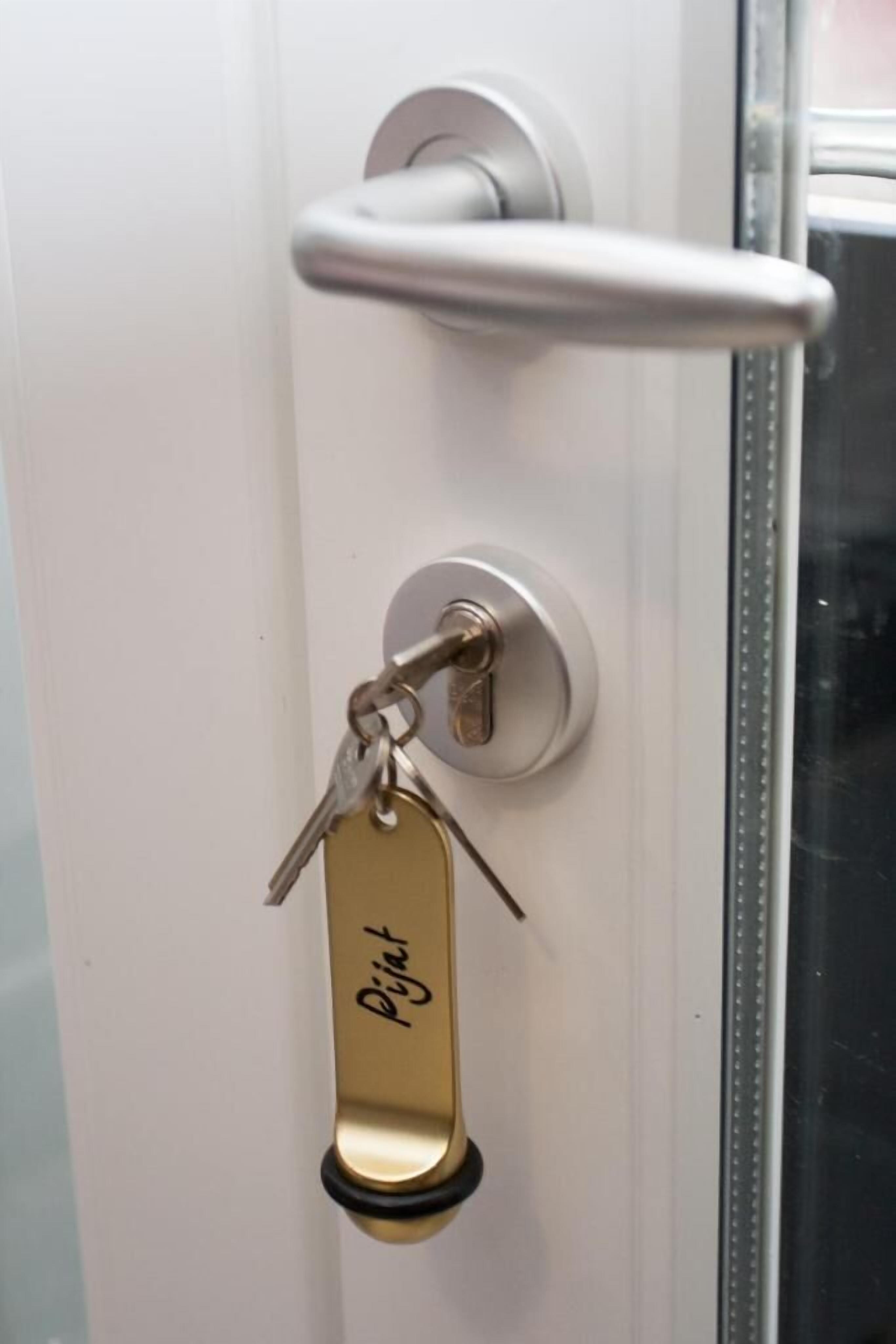 A door with a keyhole, a key, and a keychain with a tag.