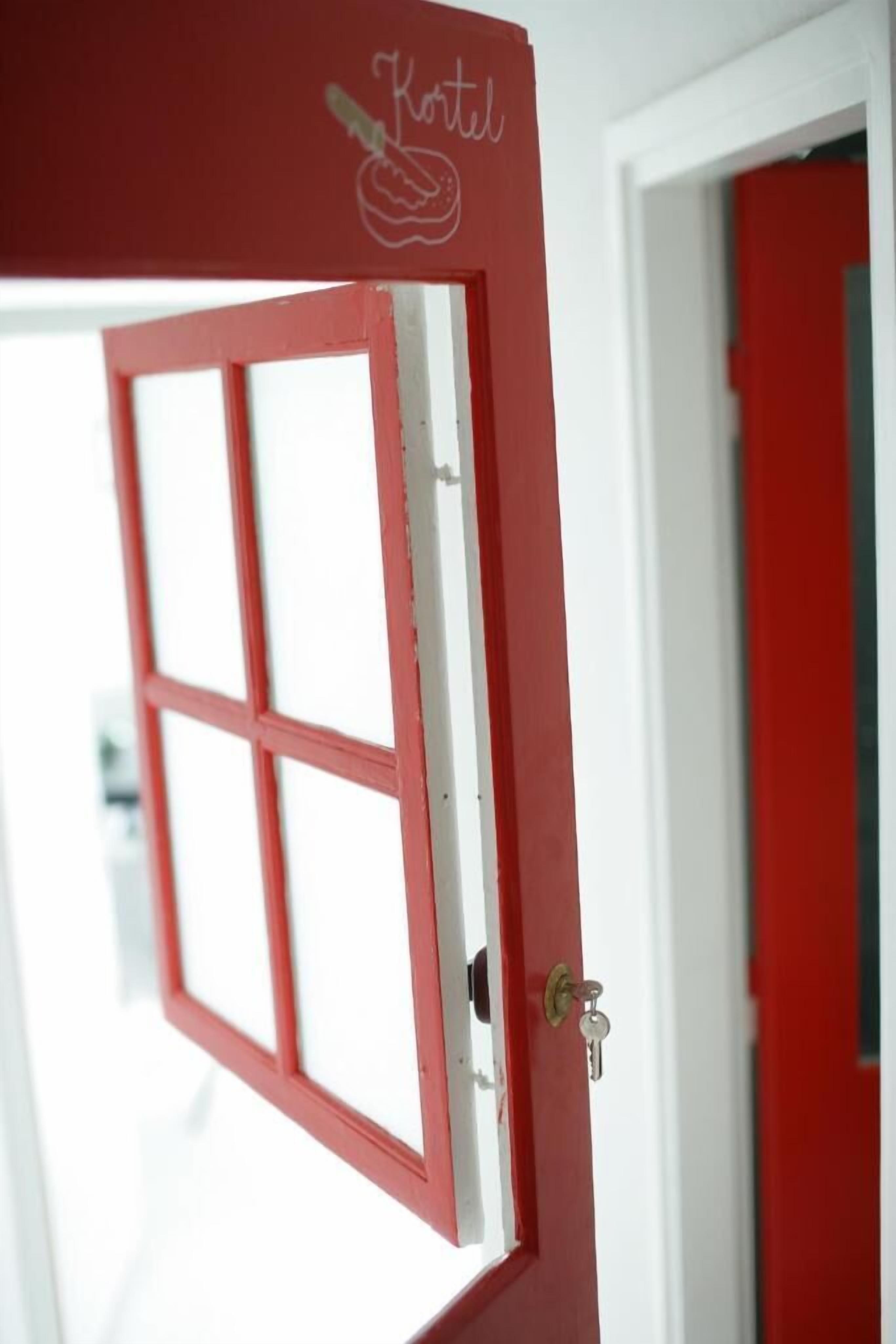 A red door with a window, a keyhole, and a lock.