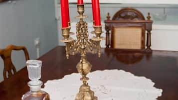 Una mesa de comedor con un candelabro decorativo, una jarra de cristal y una bandeja con vasos.