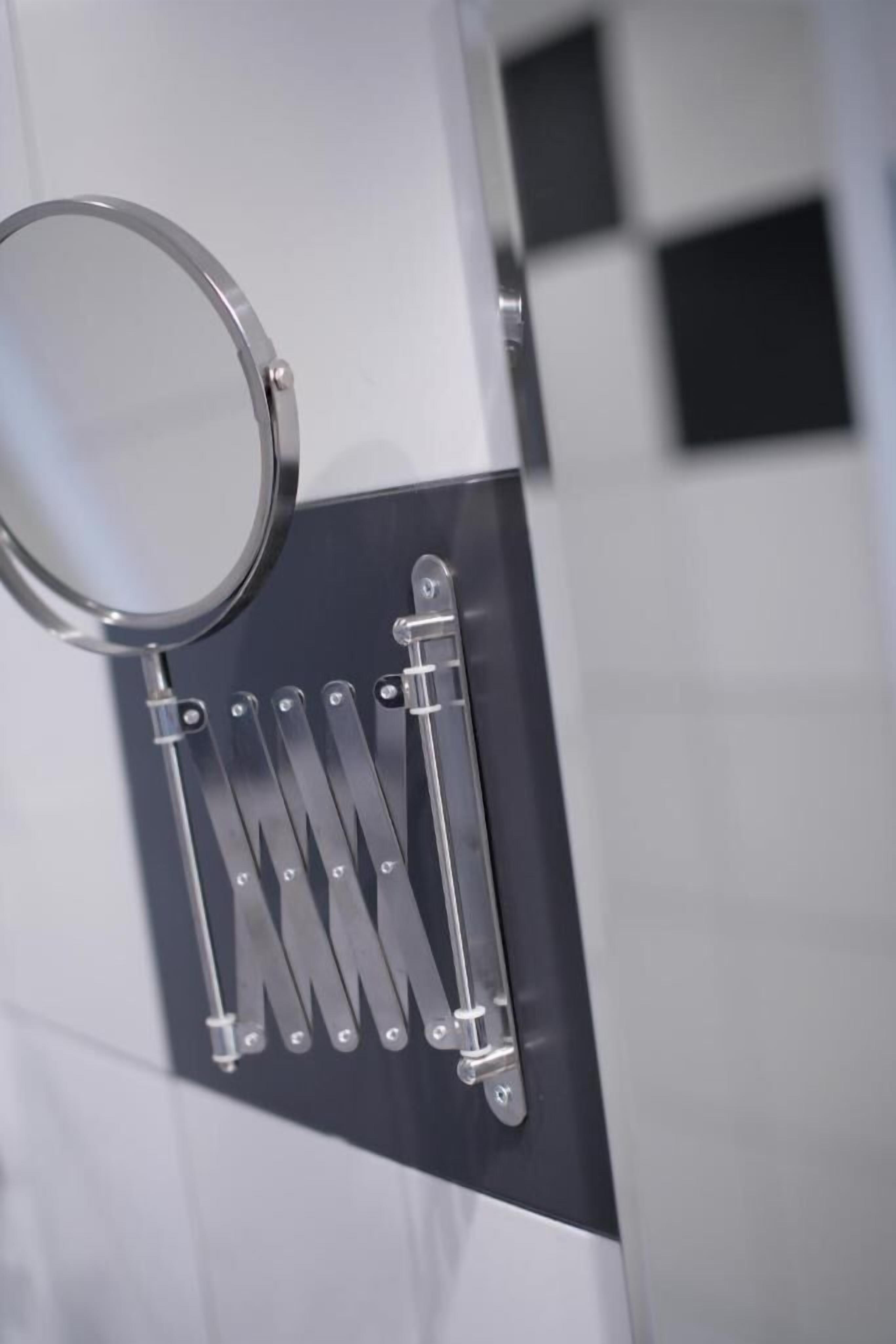 A bathroom with a mirror, towel rack, and tiled walls.