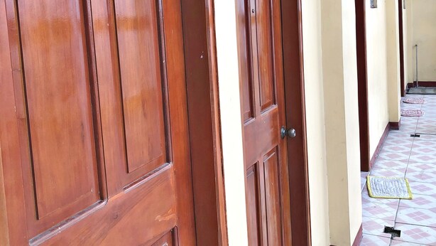 A hallway with wooden doors and a tiled floor.