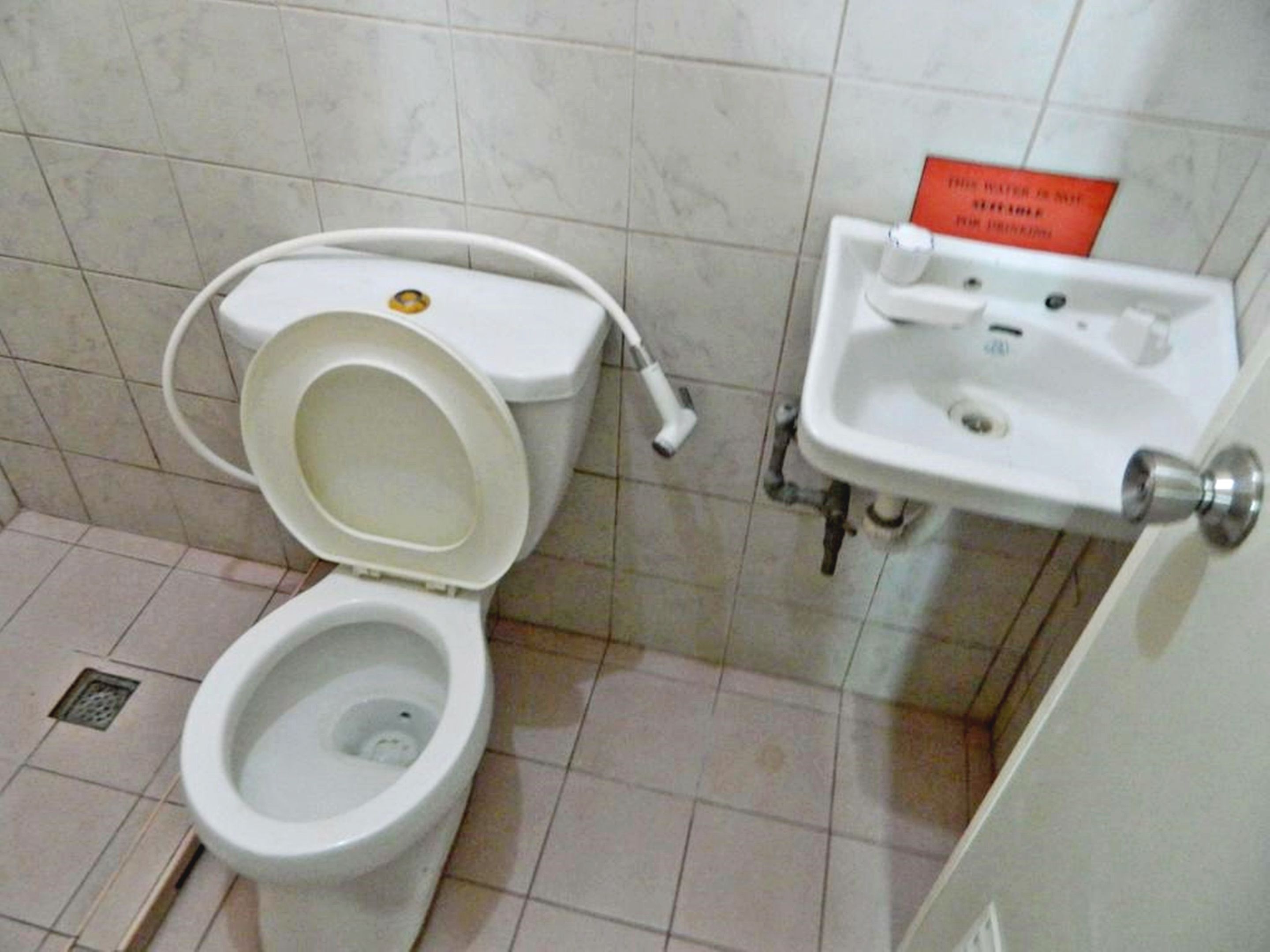 A bathroom with a toilet, a sink, and a hand dryer.