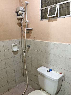 Baño pequeño con inodoro, ducha y ventana.