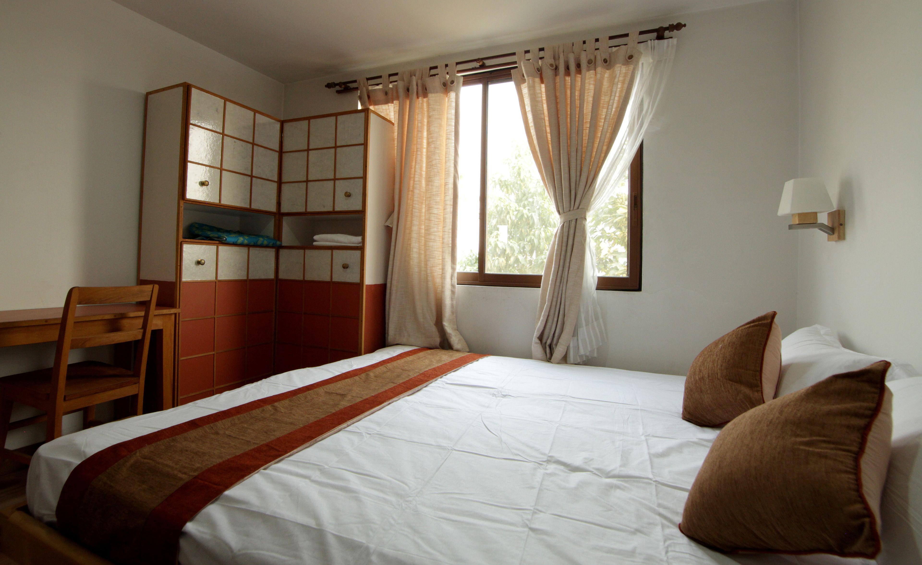 Un dormitorio con una cama, un escritorio y un armario.