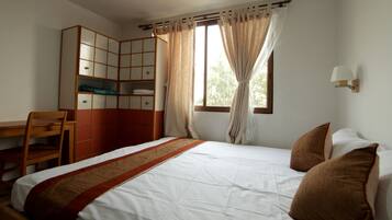 Un dormitorio con una cama, un escritorio y un armario.