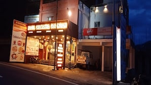 A hotel with a brightly lit entrance and signage for a restaurant. - Hotel Chakasha Govindam (Devaprayag)